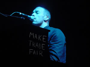 Christ Martin, of the band Coldplay, playing a piano tagged with the phrase 'Make Trade Fair'
